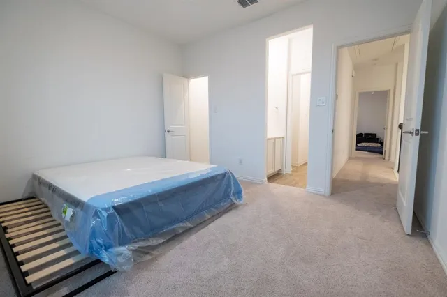 a spacious bedroom with a bed and a cabinets