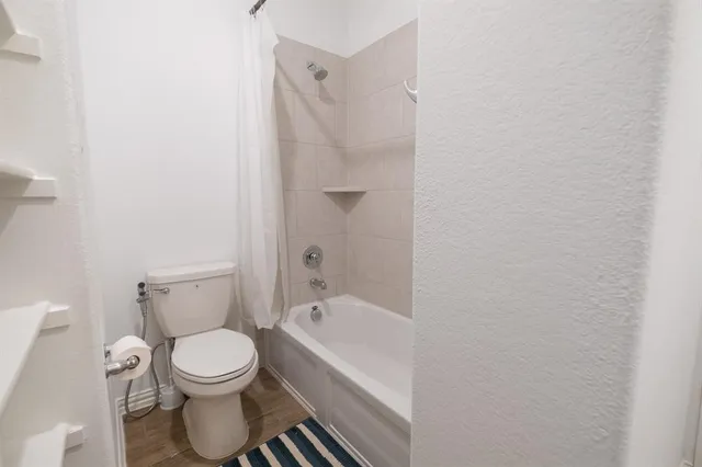 a white toilet sitting next to a bathtub