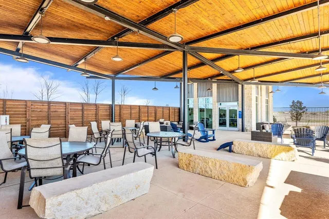a view of a patio with couches and chairs under an umbrella