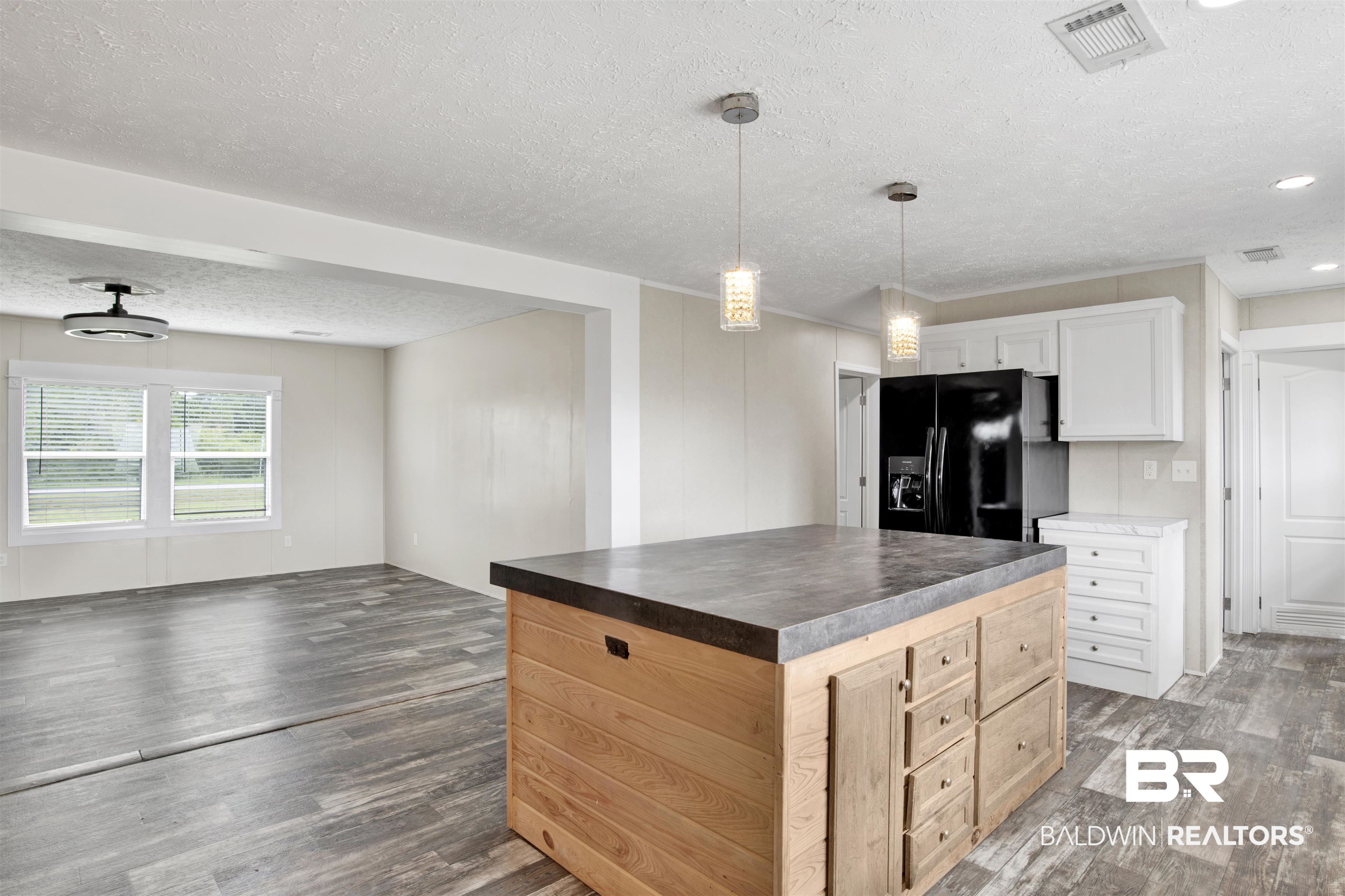 16778 County Road 87 Elberta, AL 36530 - Photo 15 of 32 Kitchen with a textured ceiling, white cabinets, dark hardwood / wood-style flooring, a kitchen island, and black refrigerator with ice dispenser