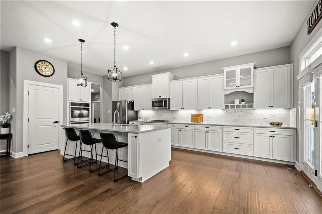 3031 Spruce Road Gibsonia, PA 15044 - Photo 21 of 49 a kitchen with center island white cabinets stainless steel appliances and wooden floor