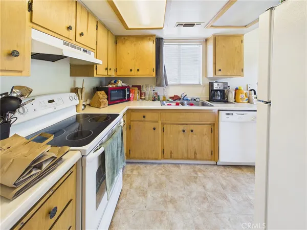 a utility room with stainless steel appliances a sink a stove and a window