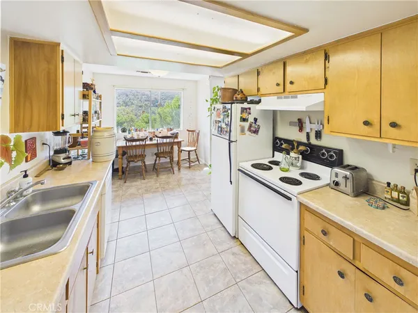 a kitchen with a sink a stove and chairs