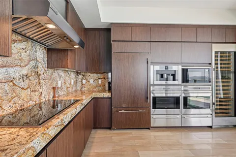 a kitchen with stainless steel appliances granite countertop a sink and a refrigerator