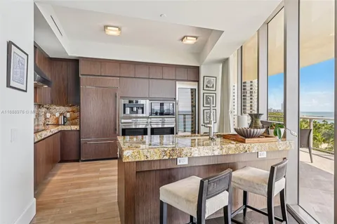 a kitchen with stainless steel appliances kitchen island granite countertop a refrigerator and cabinets