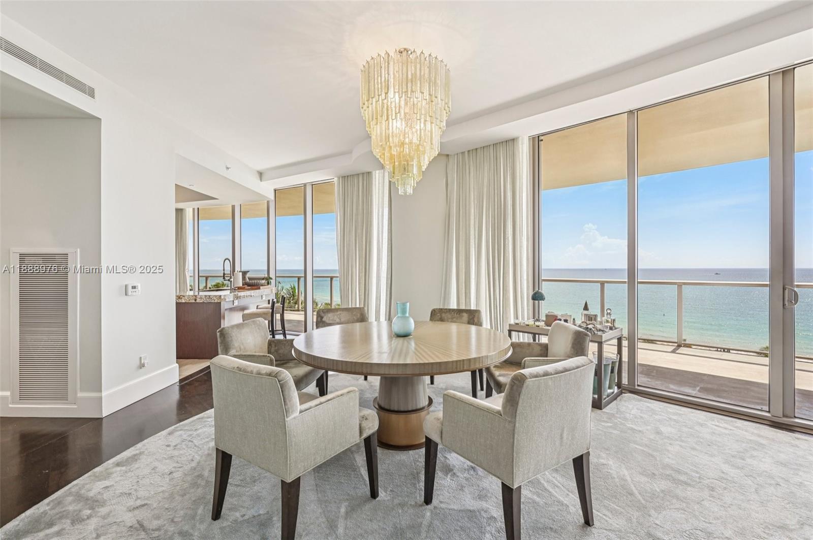 9703 Collins Avenue, Unit 600 Bal Harbour, FL 33154 - Photo 19 of 53 a dining room with furniture large windows and a chandelier