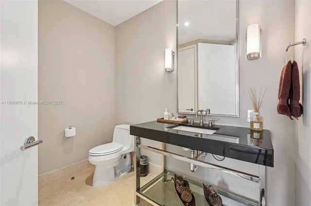 a bathroom with a granite countertop sink a toilet and a mirror