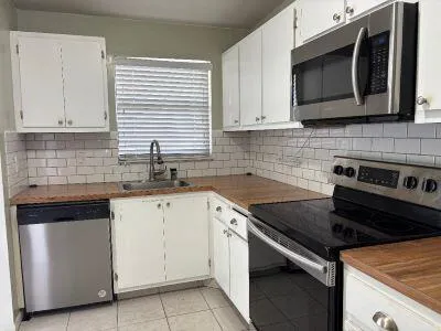 a kitchen with stainless steel appliances granite countertop a sink stove and microwave