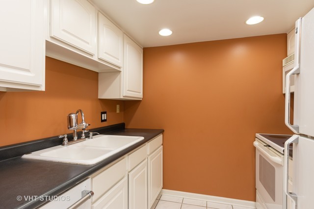 1 Renaissance Place, Unit 706 Palatine, IL 60067 - Photo 3 of 12 a kitchen with a sink cabinets and a stove top oven