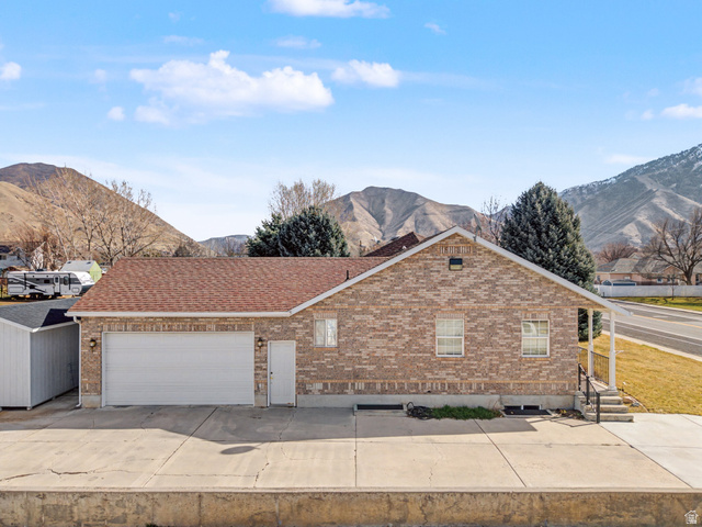 598 West 1600th Street North Mapleton, UT 84664 - Photo 25 of 34 Ranch-style home featuring a mountain view, a garage, brick siding, concrete driveway, and roof with shingles