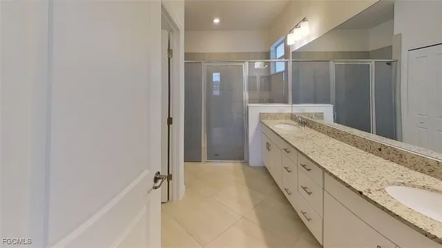 a bathroom with a granite countertop sink a mirror and a shower