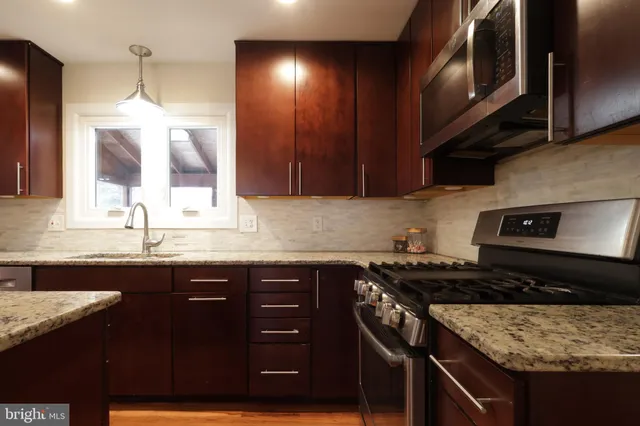 a kitchen with a sink a stove and cabinets
