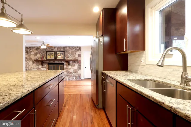 a view of a kitchen with wooden floor and a window