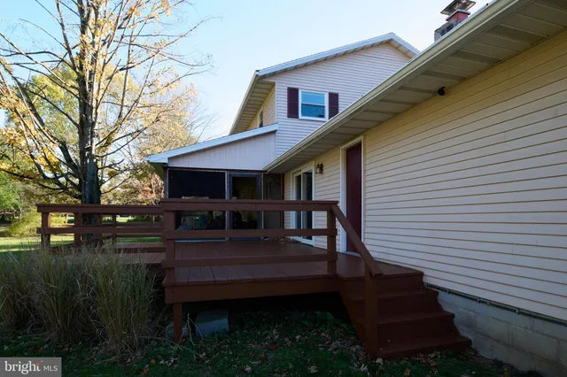 a view of backyard with deck and outdoor seating