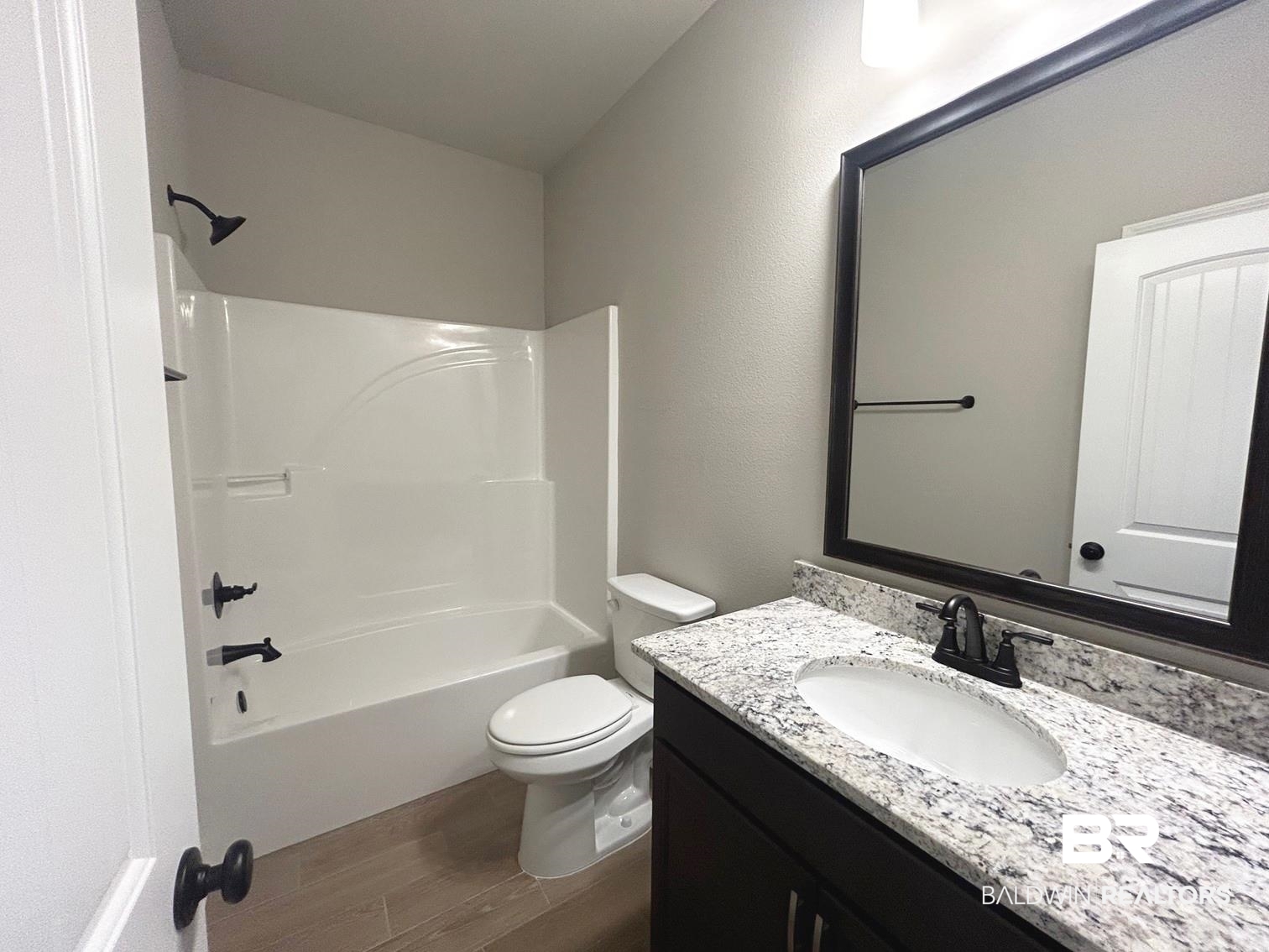 848 Sumter Loop Foley, AL 36535 - Photo 13 of 16 Full bathroom featuring vanity, toilet, hardwood / wood-style flooring, and bathing tub / shower combination