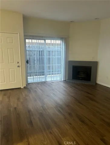 a view of empty room with wooden floor and fireplace