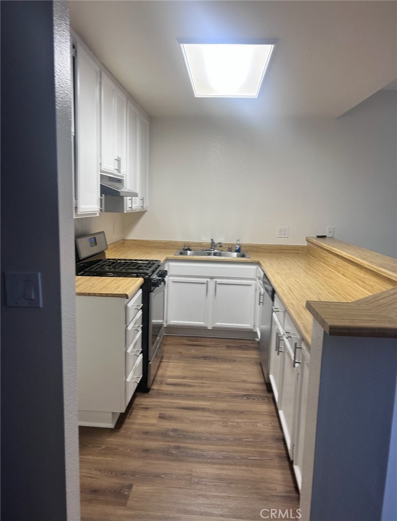 14448 Benefit Street, Unit 3 Sherman Oaks, CA 91423 - Photo 4 of 11 a kitchen with a stove top oven sink and cabinets