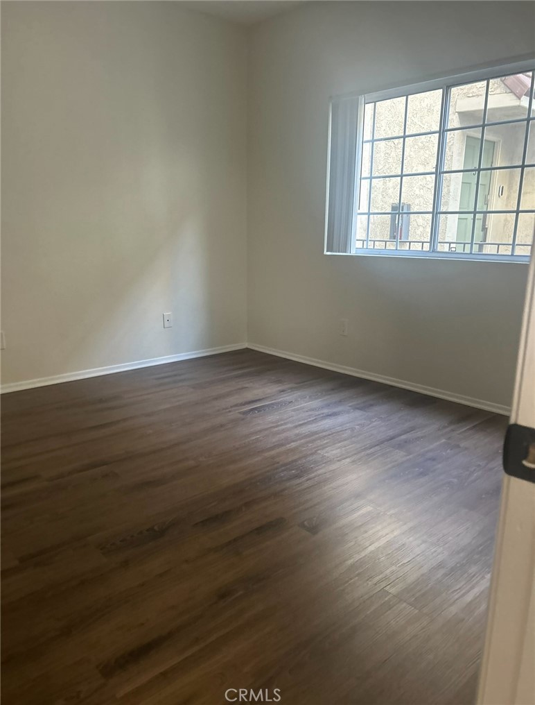 14448 Benefit Street, Unit 3 Sherman Oaks, CA 91423 - Photo 6 of 11 an empty room with wooden floor and windows