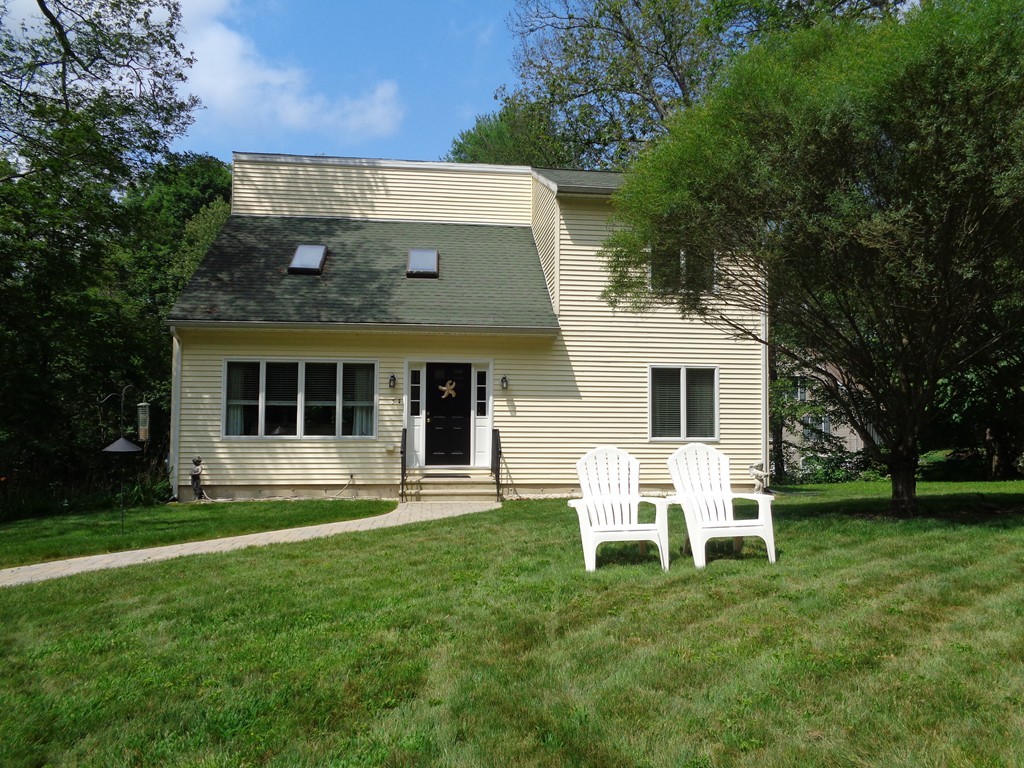 a view of a white house with a yard and sitting area