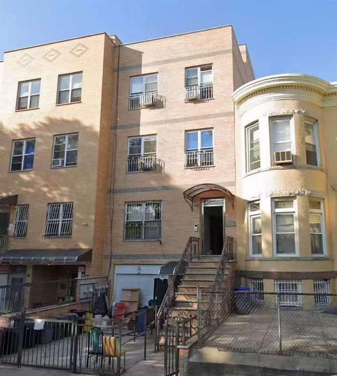 959 55th Street Brooklyn, NY 11219 - Photo 1 of 1 a front view of a residential apartment building with a yard
