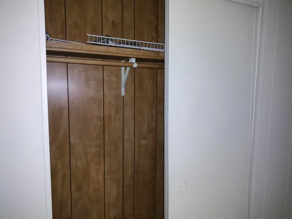 an empty room with a chair and a window