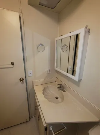 a bathroom with a tub a sink and mirror