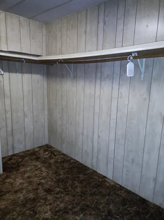 an empty room with a ceiling fan and carpet