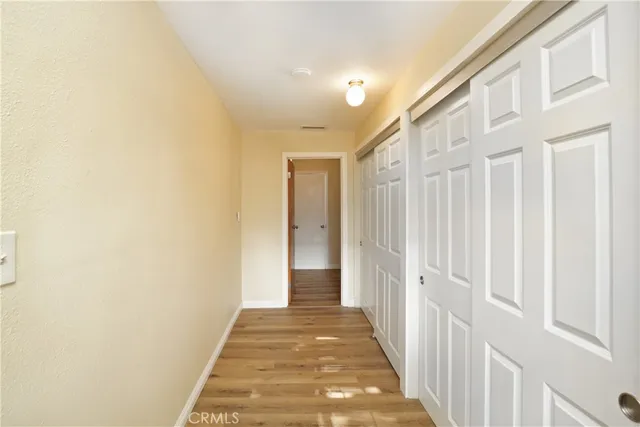 a view of a hallway with wooden floor and entryway