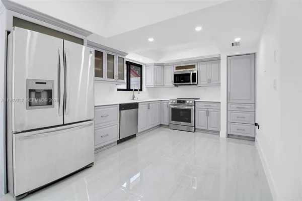 a kitchen with stainless steel appliances granite countertop a refrigerator and a stove top oven