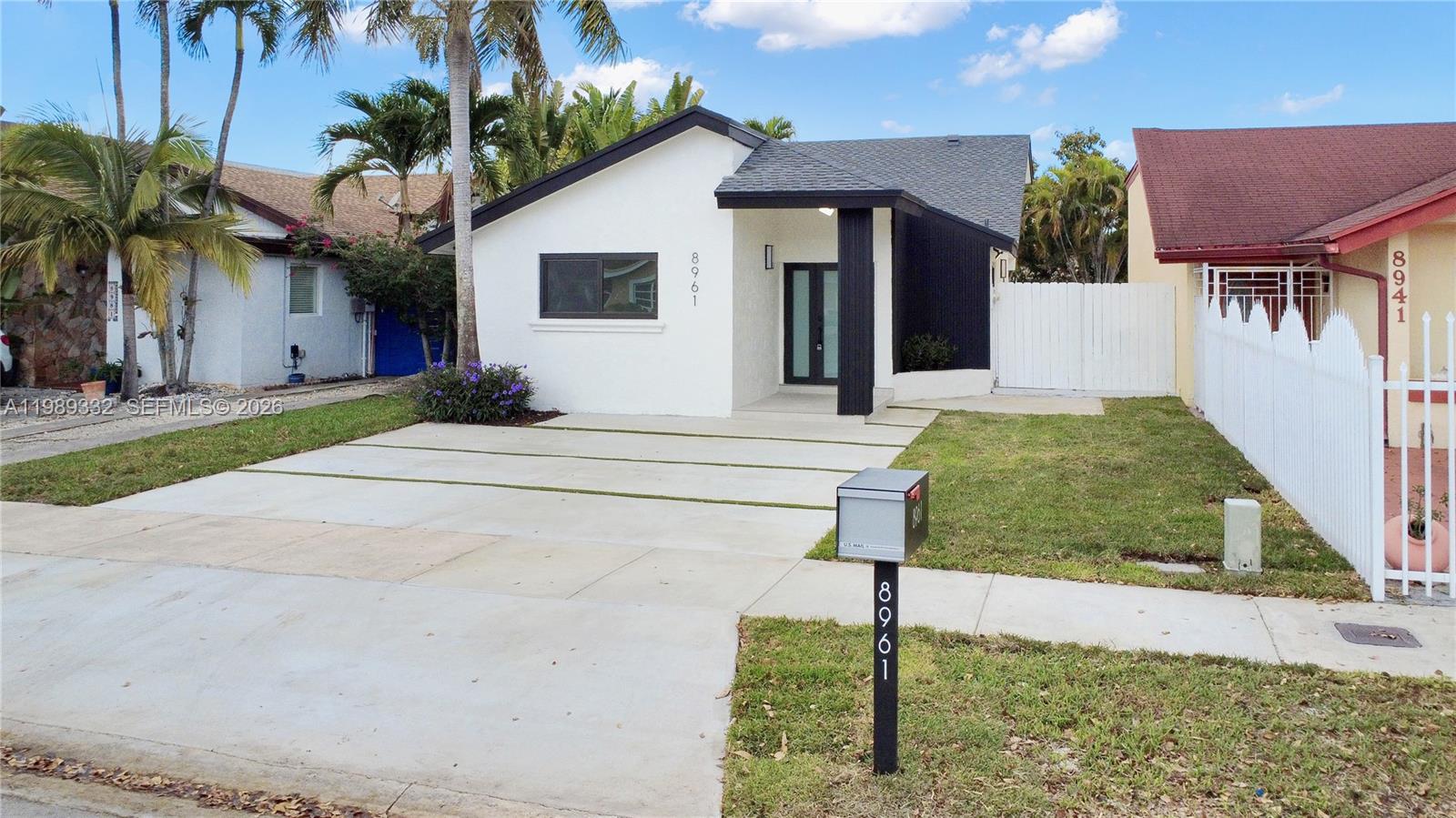 8961 Southwest 6th Street Miami, FL 33174 - Photo 17 of 26 a front view of a house with a yard and garage