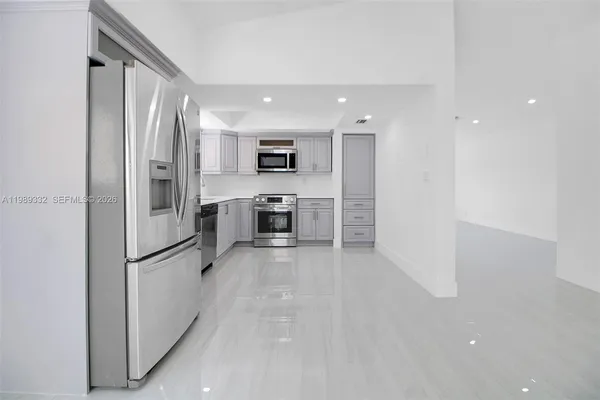 a kitchen with stainless steel appliances granite countertop a refrigerator and a stove