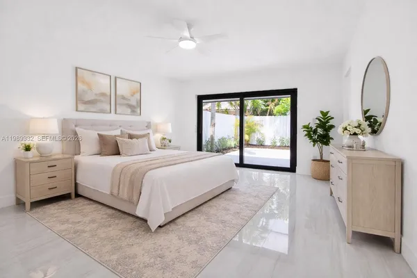 a spacious bedroom with a balcony a bed and a potted plant