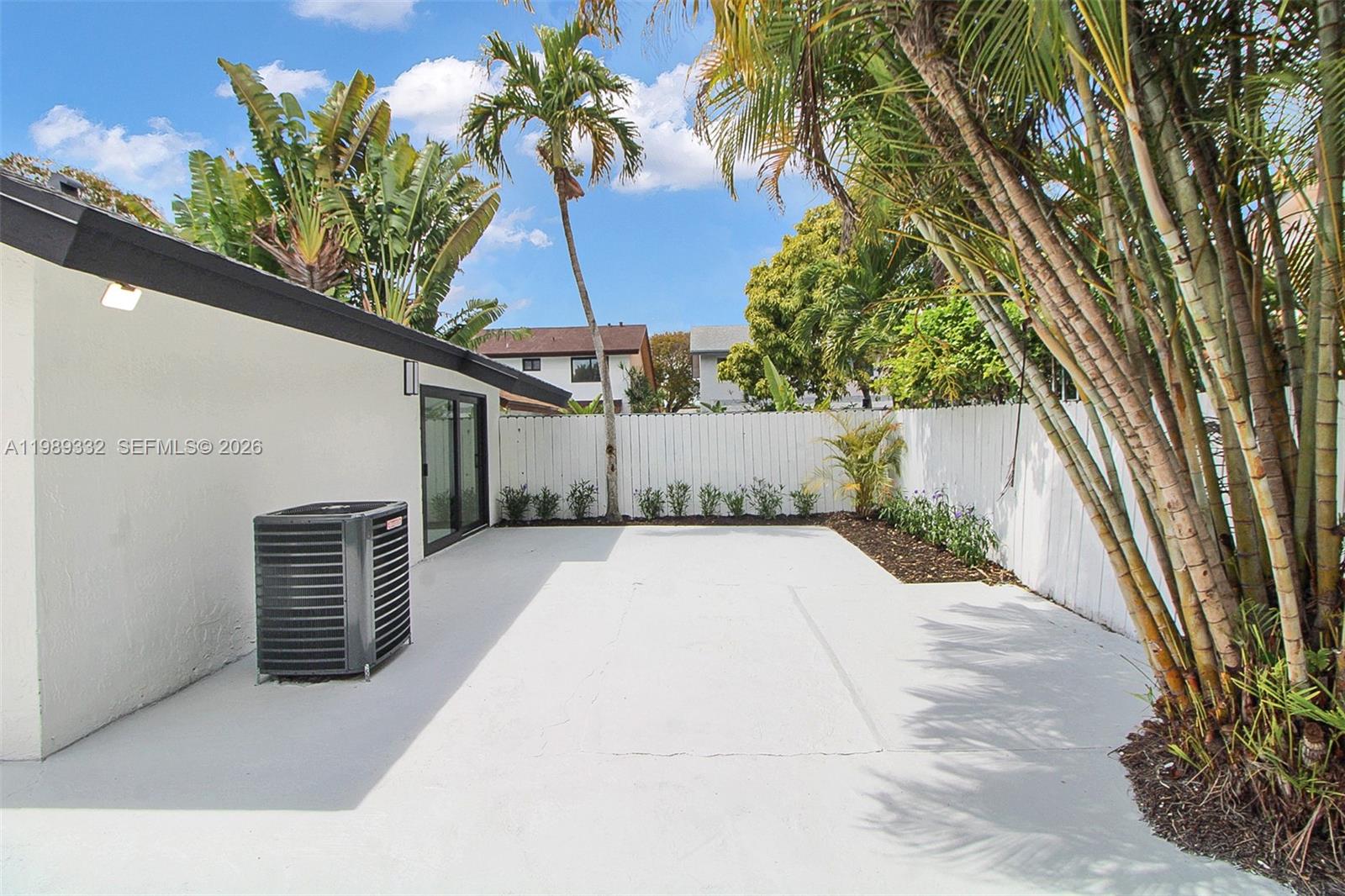 8961 Southwest 6th Street Miami, FL 33174 - Photo 21 of 26 a backyard of a house with table and chairs under an umbrella