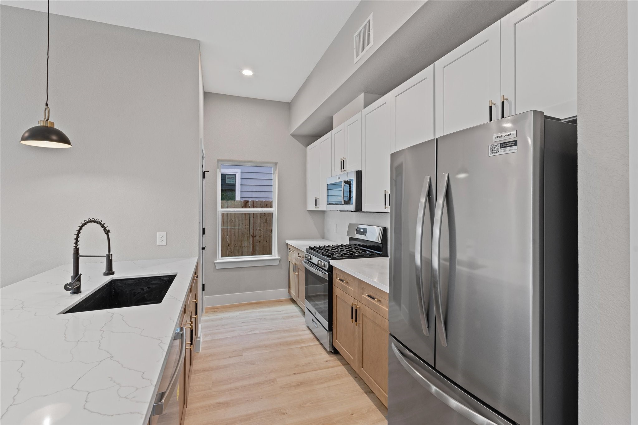 7349 Sandle Street, Unit A Houston, TX 77088 - Photo 13 of 18 a kitchen with stainless steel appliances a refrigerator sink and cabinets