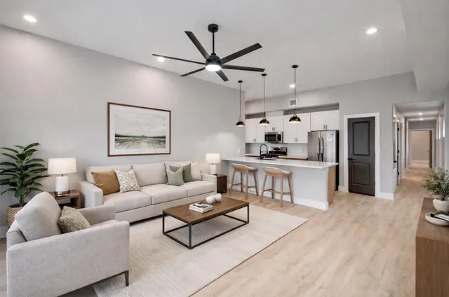 a living room with furniture and kitchen view