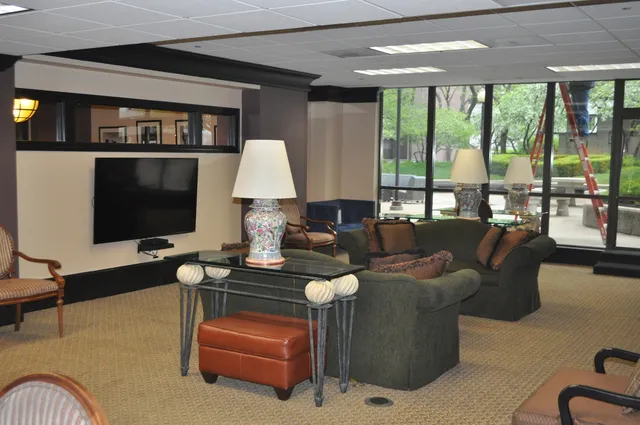 a room with table chairs and paintings on wall