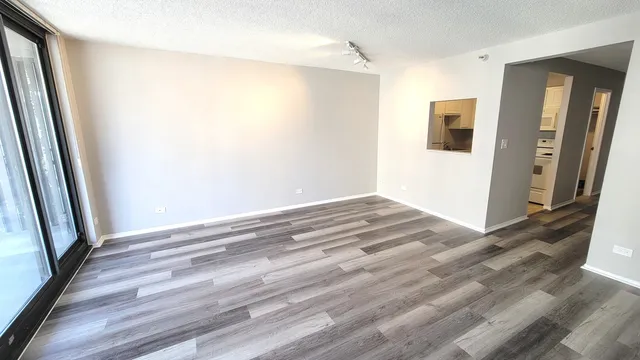 a view of a big room with wooden floor and a bathroom