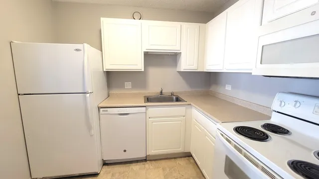 a kitchen with a refrigerator sink stove and cabinets