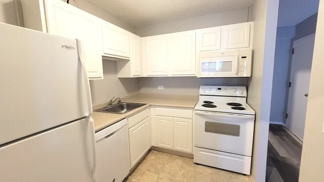 a kitchen with white cabinets and white appliances