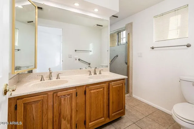 a bathroom with a granite countertop sink toilet and mirror