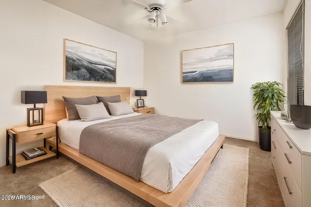 a bedroom with bed and paintings on the wall