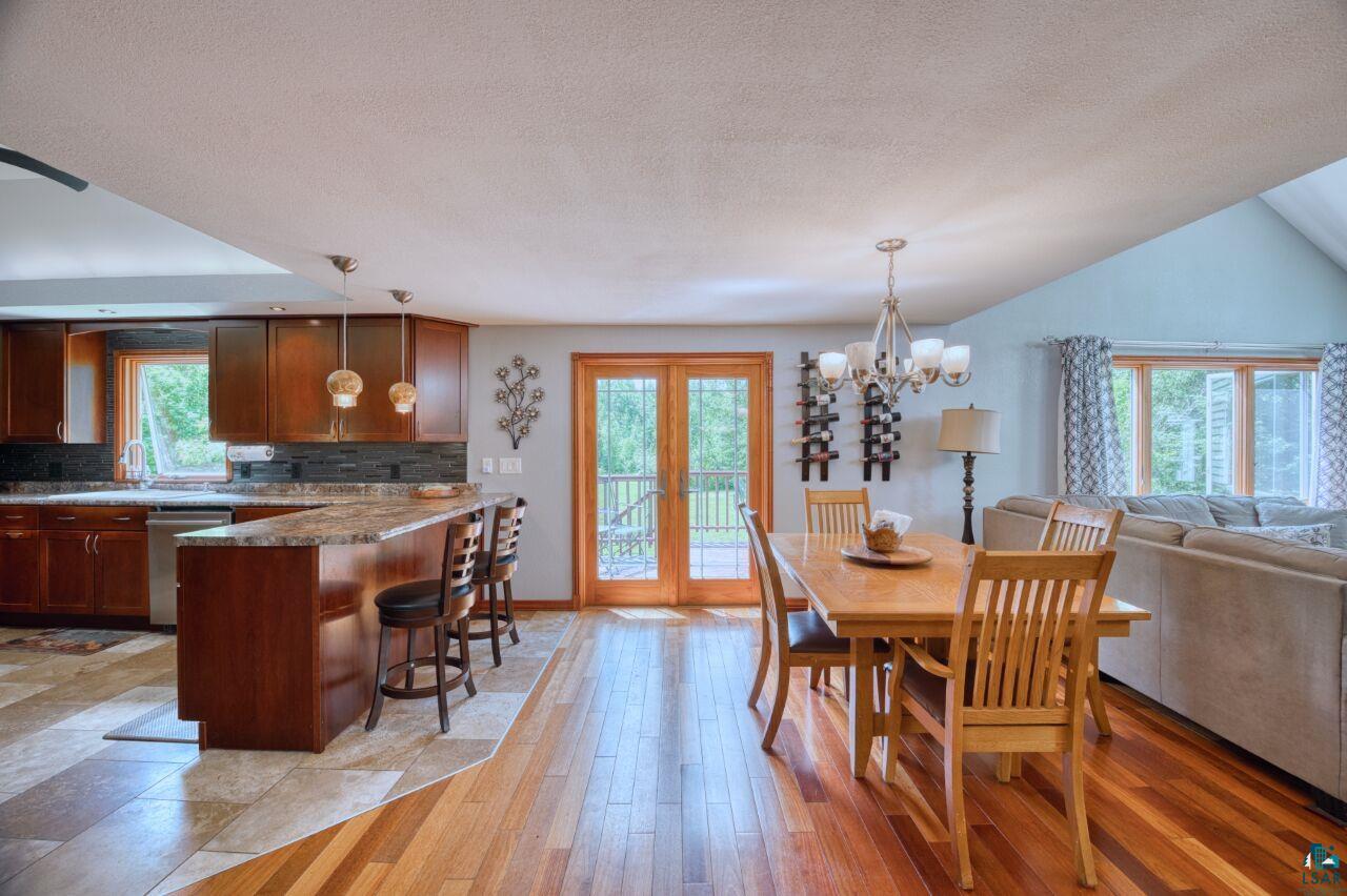 3935 Saari Road Hibbing, MN 55746 - Photo 11 of 48 Tiled dining space featuring vaulted ceiling, a chandelier, and french doors