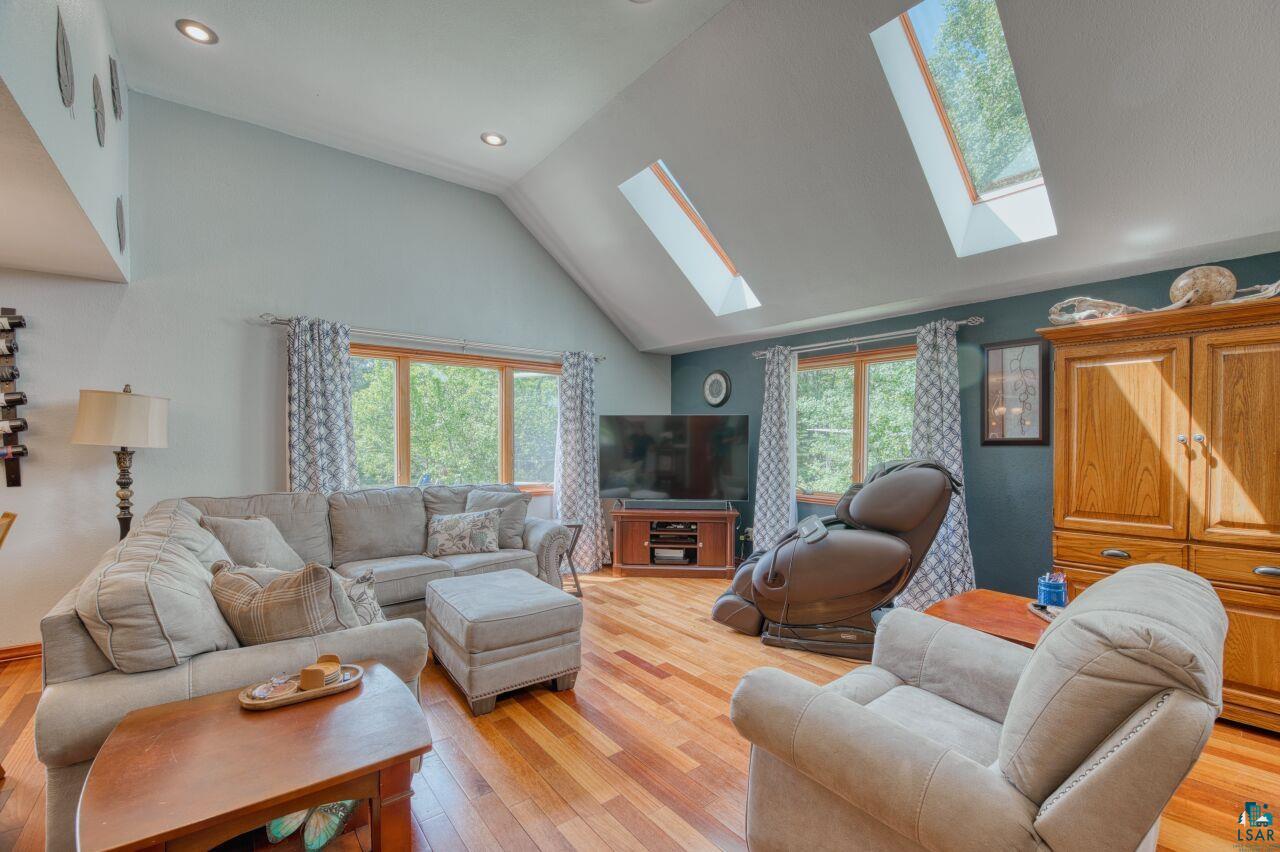 3935 Saari Road Hibbing, MN 55746 - Photo 4 of 48 Living room featuring high vaulted ceiling, light wood-type flooring, and a skylight