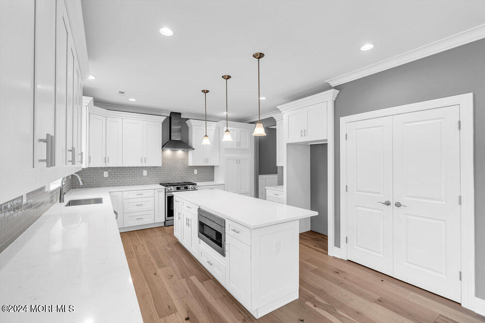 12 Sander Way Bayville, NJ 08721 - Photo 25 of 71 a large white kitchen with a stove a sink dishwasher and a refrigerator with wooden floor