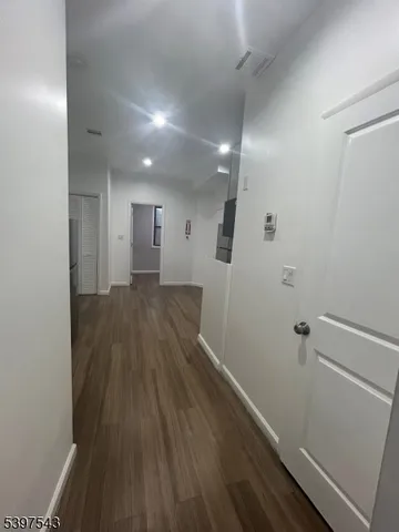 a view of a hallway with wooden floor