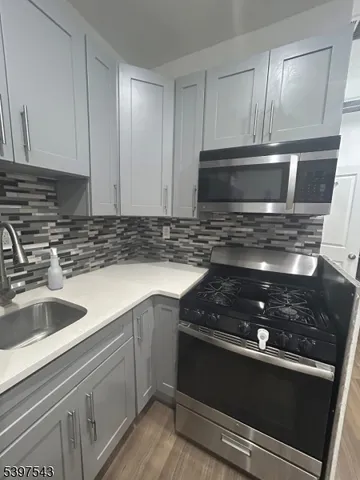 a kitchen with stainless steel appliances granite countertop a sink stove and microwave