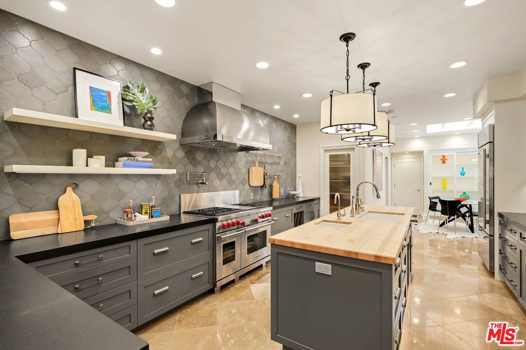 2305 Canyonback Road Los Angeles, CA 90049 - Photo 15 of 50 a kitchen with stainless steel appliances granite countertop a sink a stove and a wooden floors