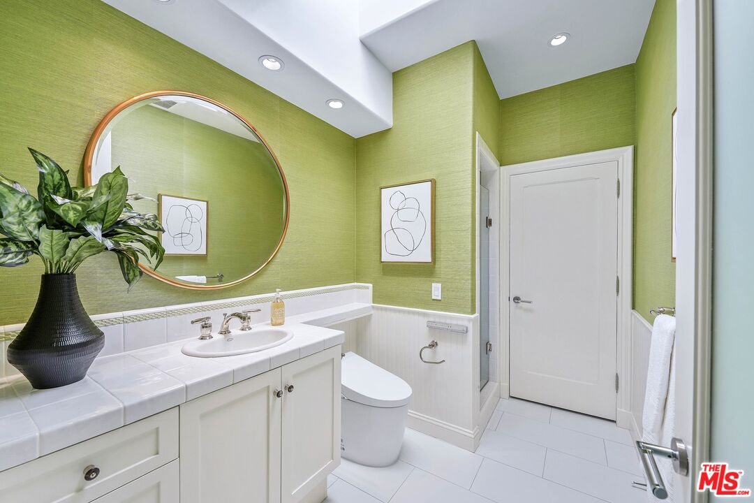 2305 Canyonback Road Los Angeles, CA 90049 - Photo 33 of 50 a bathroom with a granite countertop toilet sink and mirror