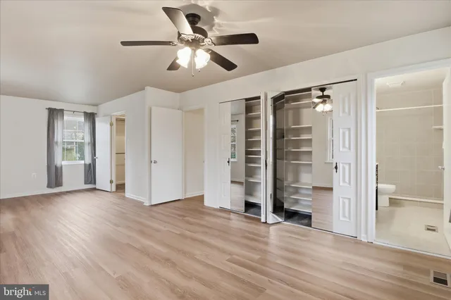a view of empty room with wooden floor and window