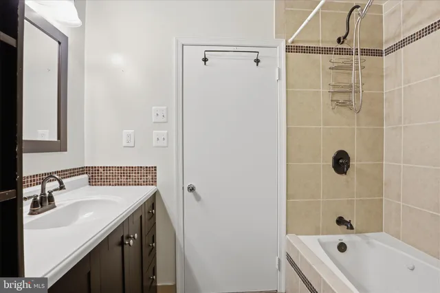 a bathroom with a tub sink shower and mirror